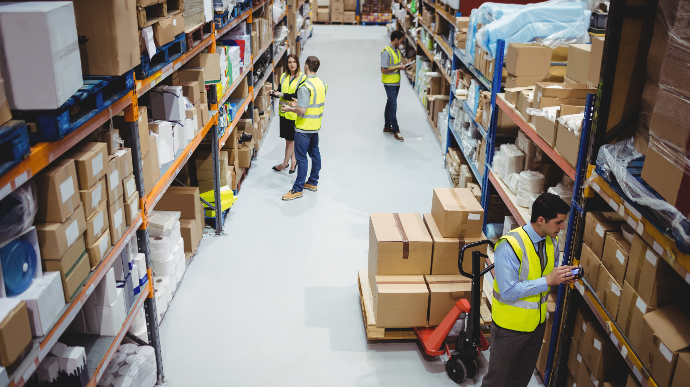 People in high vis vests working in a warehouse People in high vis vests working in a warehouse